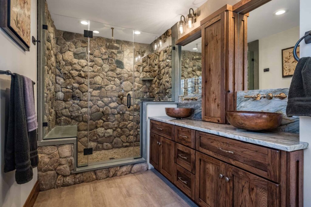 Moderne douche met natuurstenen wandafwerking en houten wastafelmeubel